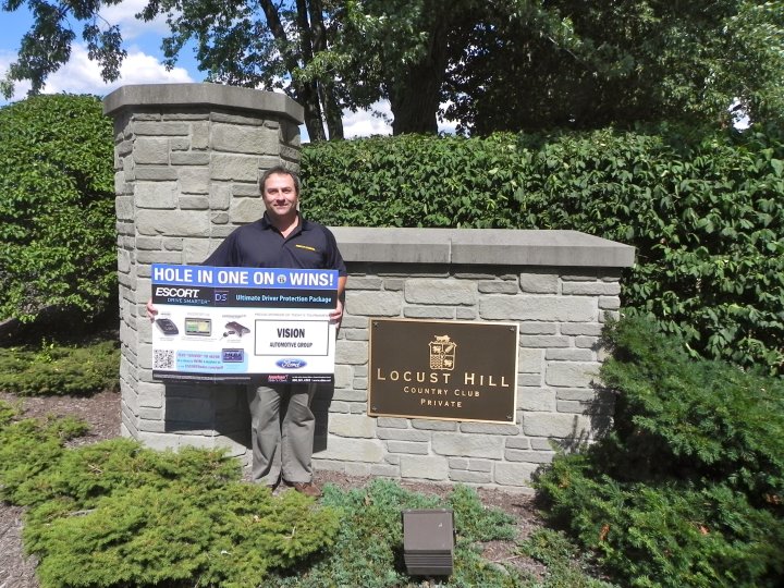 Winning Golfer posing for photo infront of the Locust Hill sign