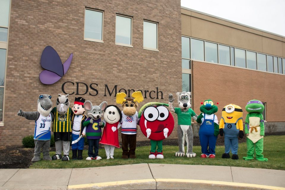 A big group of Mascots lined up infront of the CDS Monarch Building