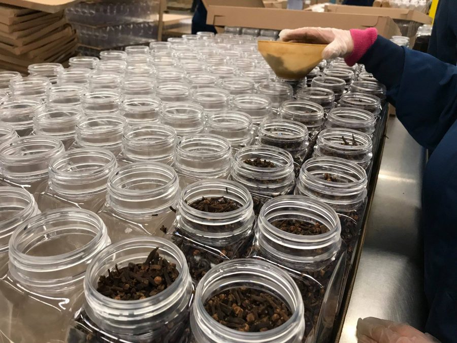 Unistel spices lined up while an employee fills the spice containers